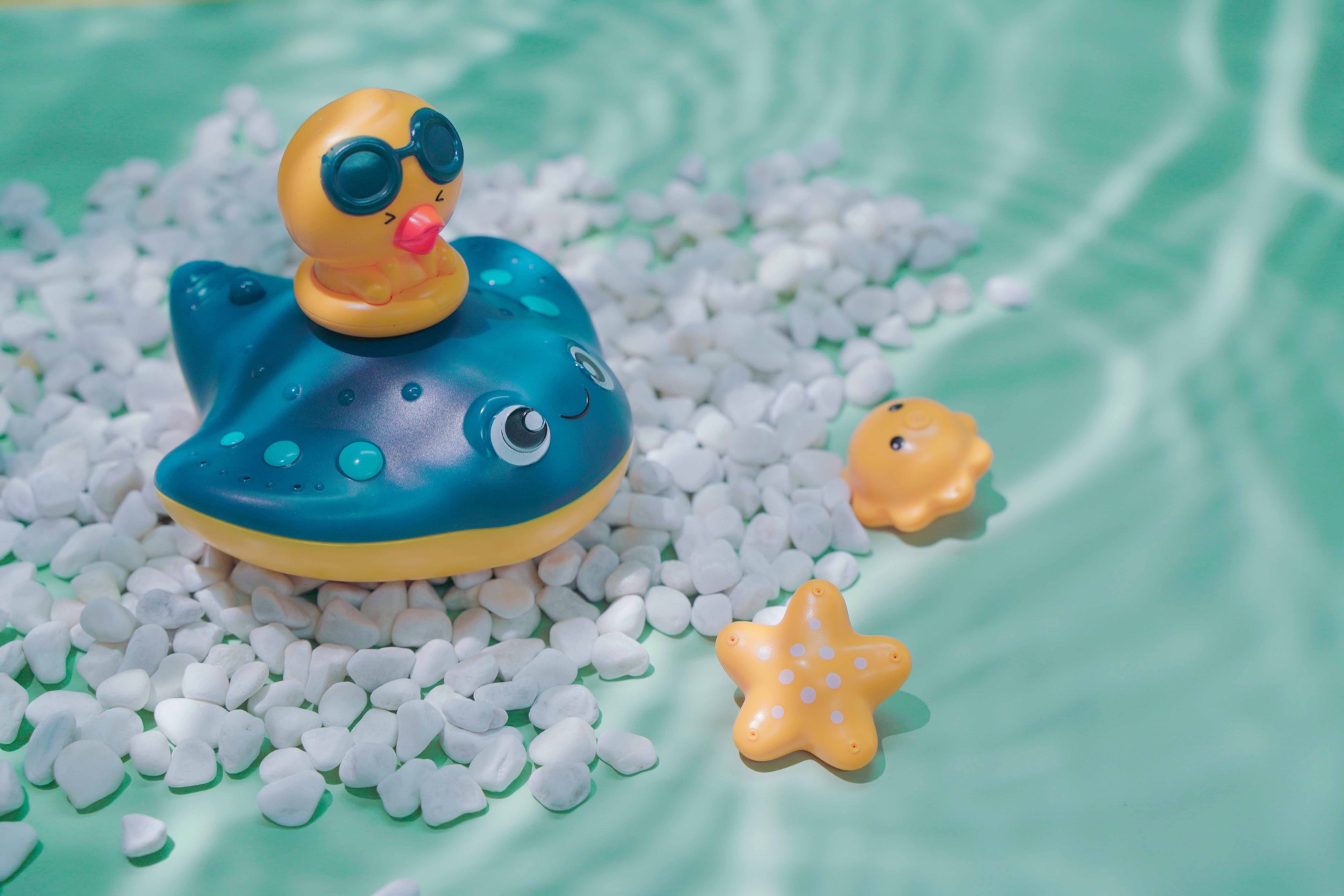 蓝绿色水景中的鲸鱼、鸭子和海星沐浴玩具